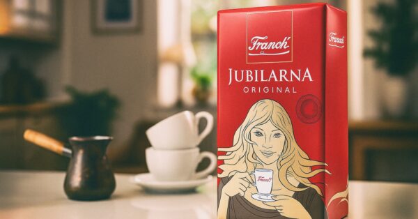 Pakiranje Franck Jubilarne mljevene kave na stolu, uz džezvu i dvije šalice u pozadini.