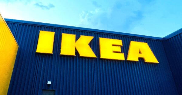Veliki žuti natpis IKEA na plavoj fasadi trgovine namještajem.