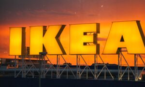 Osvijetljeni logotip IKEA-e na krovu zgrade u suton.
