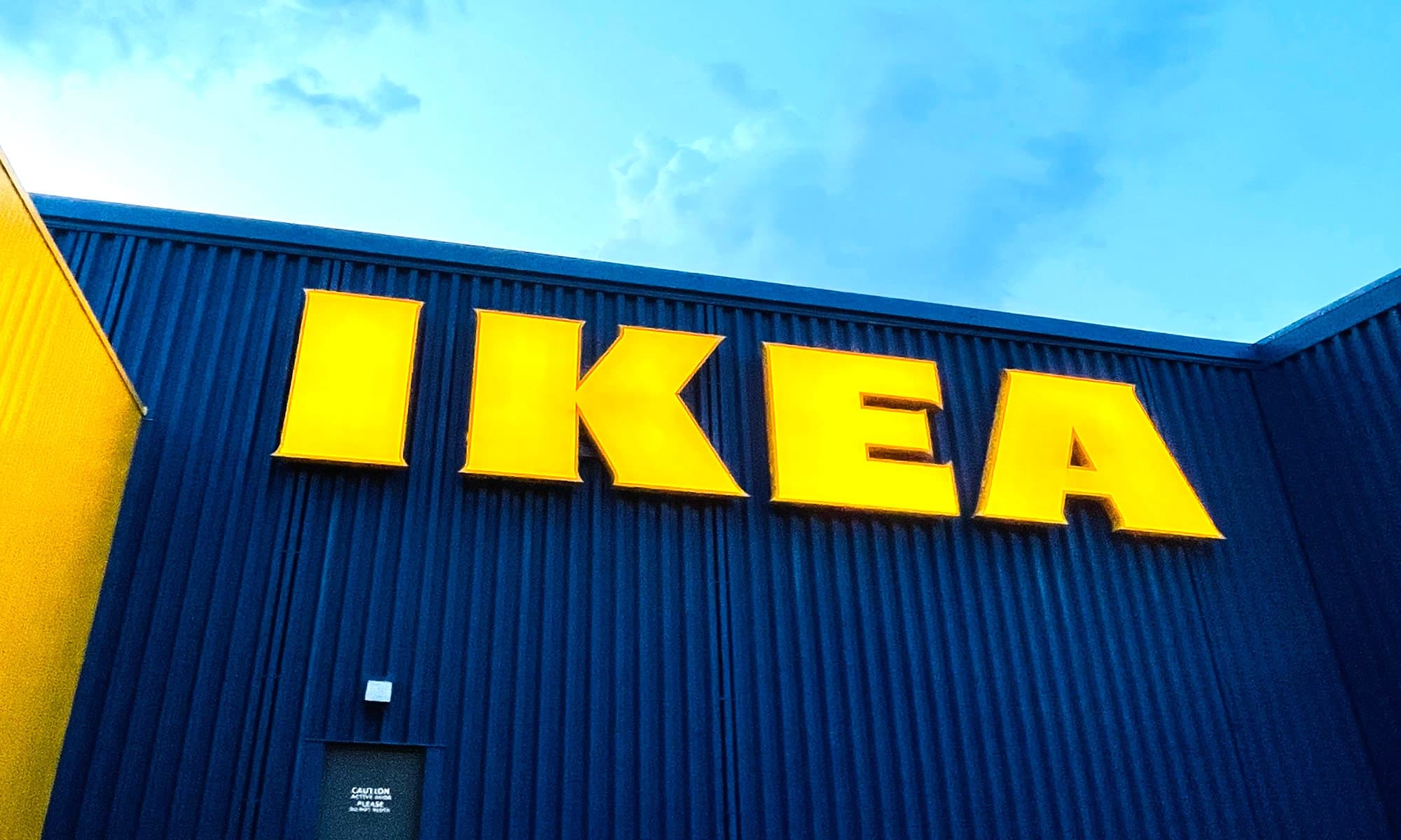 Veliki žuti natpis IKEA na plavoj fasadi trgovine namještajem.