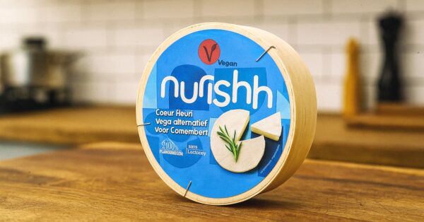 Pakiranje veganske zamjene za sir Nurishh Coeur Fleuri na drvenoj radnoj površini u kuhinji.