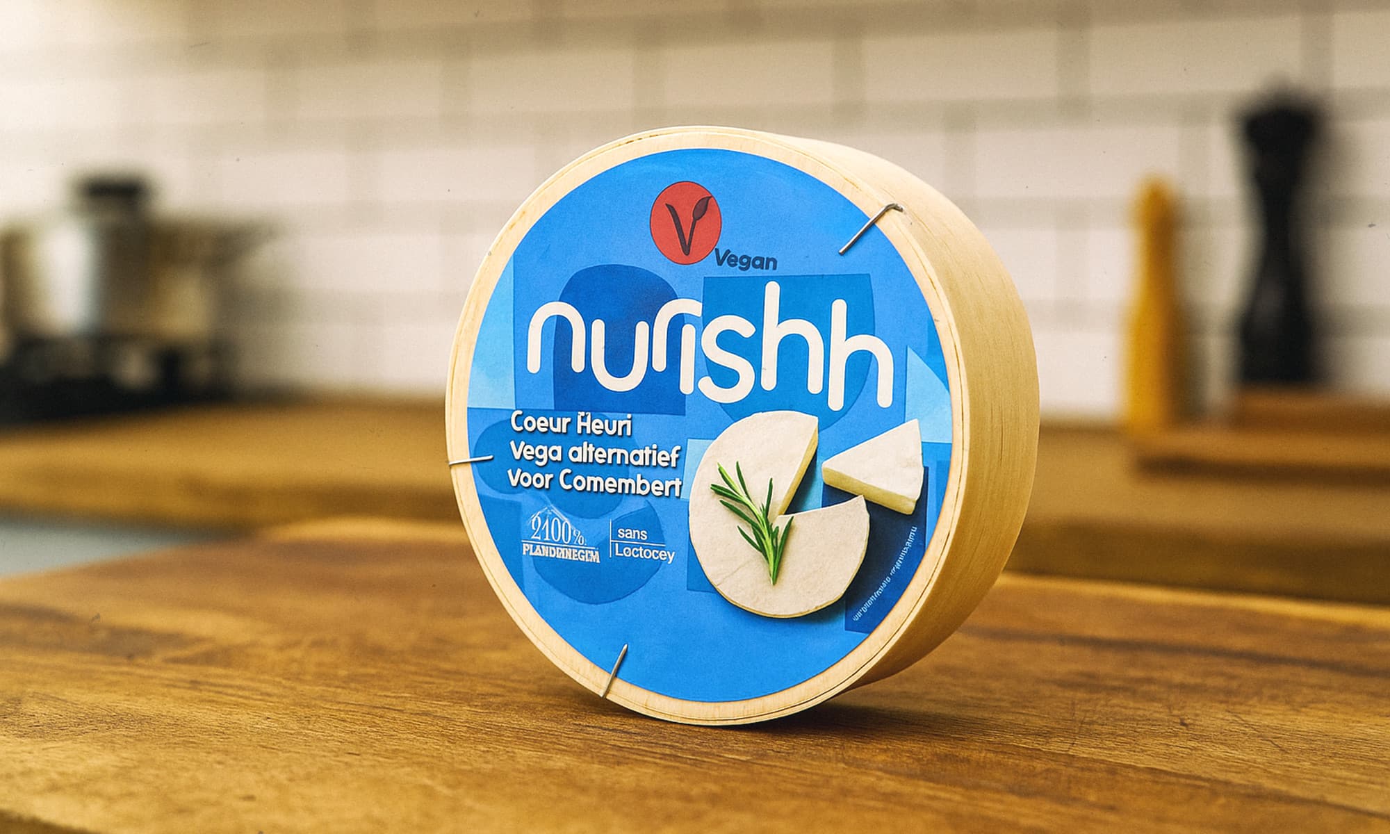 Pakiranje veganske zamjene za sir Nurishh Coeur Fleuri na drvenoj radnoj površini u kuhinji.