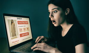 Mlada žena šokiranog izraza lica gleda u laptop na kojem je otvorena stranica Shein s porukom 'Hurry! Only 3 left!', što ilustrira tipičan primjer žurnog marketinga i FOMO efekta u online kupovini.