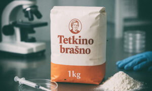 Paket brašna Tetkino brašno od 1 kg na laboratorijskom stolu uz mikroskop, špricu i rukavicu.